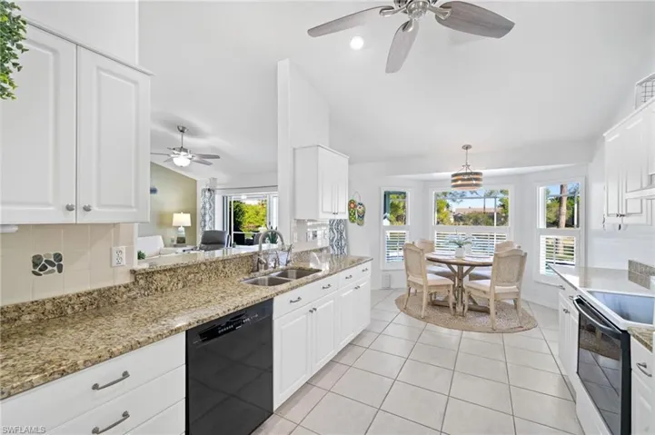 Kitchen featuring lofted ceiling, white cabinets, range with electric cooktop, sink, and black dishwasher