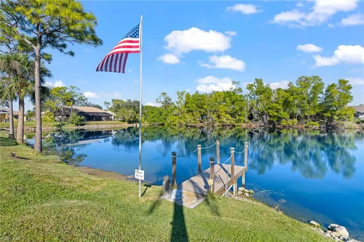 View of dock with a yard and a water view