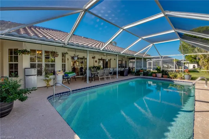 View of swimming pool with a patio, glass enclosure, and ceiling fan