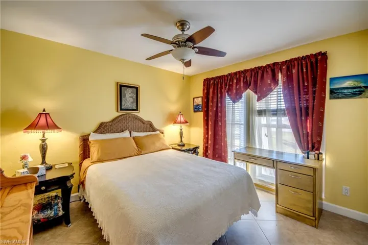 Tiled bedroom featuring ceiling fan
