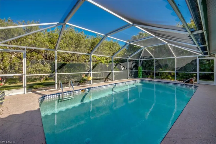 View of pool with a lanai and a patio
