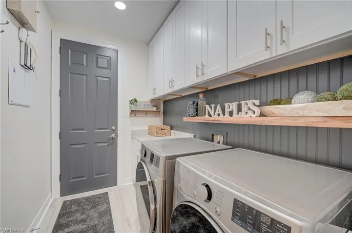 Laundry area with cabinet space, independent washer and dryer, light wood-style flooring, and recessed lighting