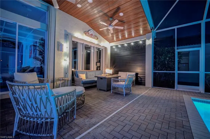 View of patio with an outdoor living space with a fire pit and a ceiling fan