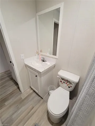 Half bathroom featuring vanity and light wood-style flooring