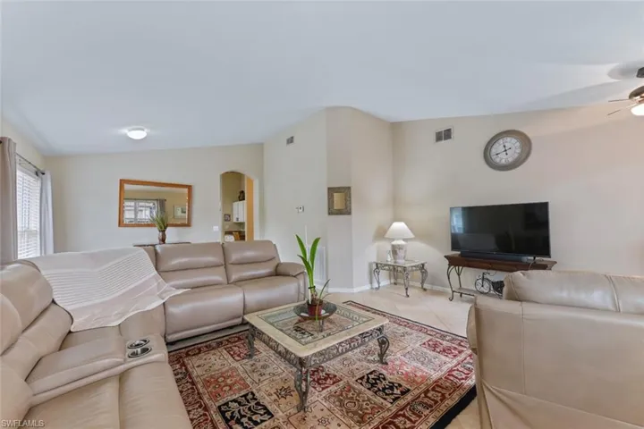 Tiled living room with lofted ceiling and arched walkways