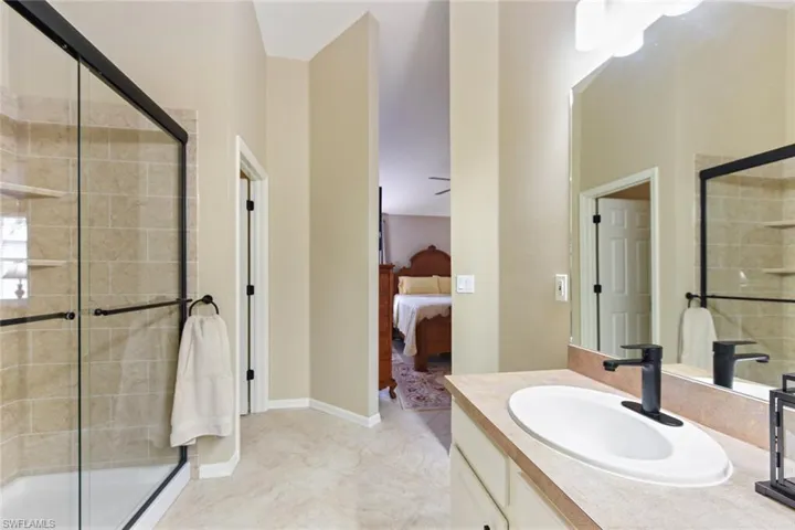 Bathroom featuring a shower stall, vanity, and ensuite bathroom