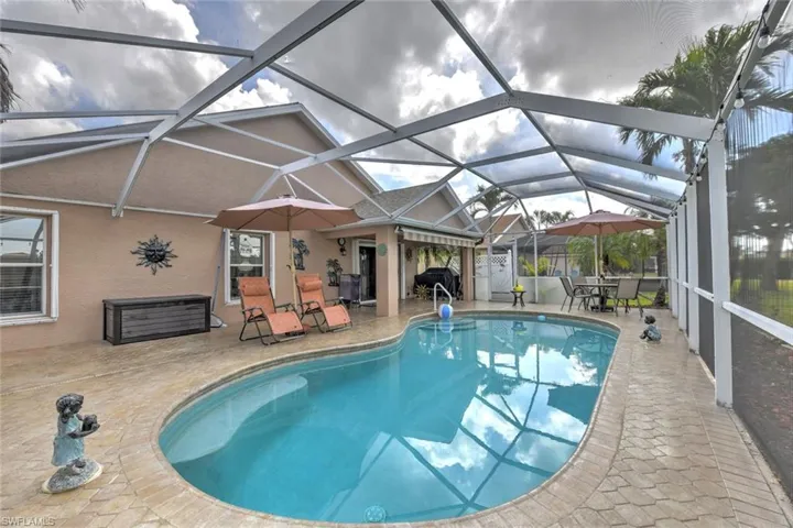 Outdoor pool with a sunroom, a patio, and glass enclosure