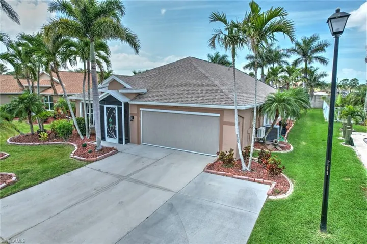 View of front facade with a front yard, a shingled roof, an attached garage, concrete driveway, and stucco siding
