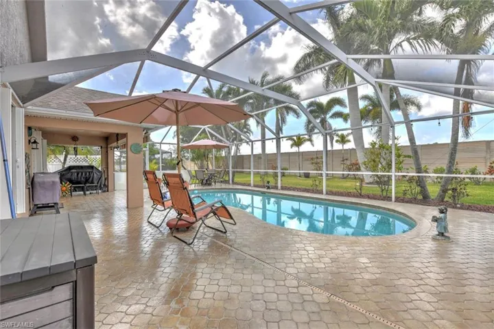 View of swimming pool featuring a patio area, glass enclosure, and a sunroom