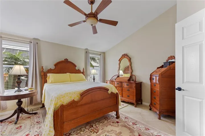 Bedroom featuring vaulted ceiling, a ceiling fan, and light tile patterned floors