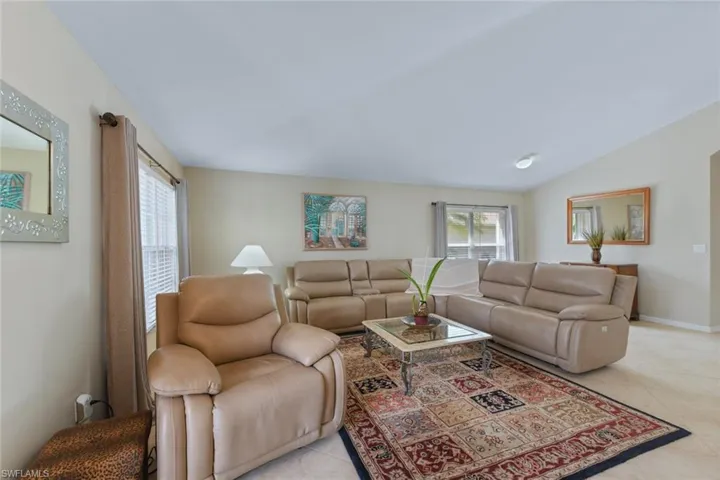 Living area with light tile patterned floors and lofted ceiling