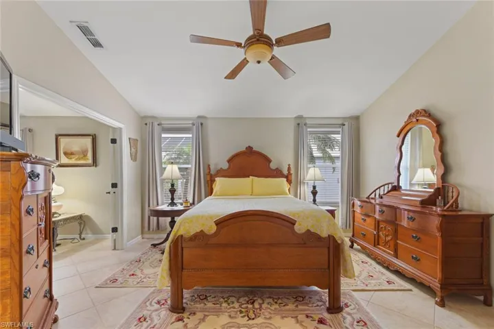 Bedroom featuring light tile patterned floors, multiple windows, and a ceiling fan