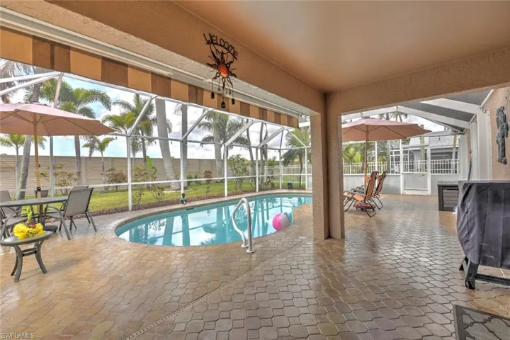 Swimming pool with a fenced backyard, a patio, a lanai, and a sunroom