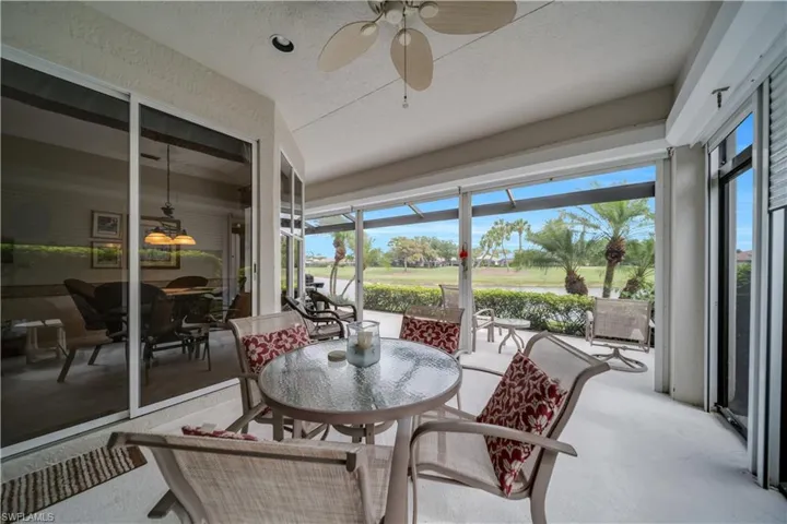 Sunroom / solarium with ceiling fan, outdoor dining area, and golf course view