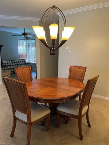 Recessed archway, crown molding, tile flooring, and a ceiling fan