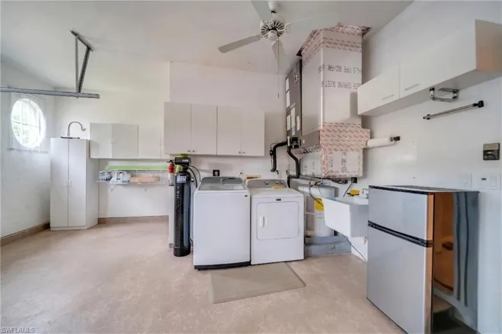 Laundry area featuring ceiling fan, washer and dryer, and light flooring