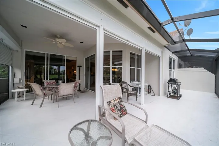 View of patio / terrace with outdoor dining space, a sunroom, a ceiling fan, grilling area, and a lanai
