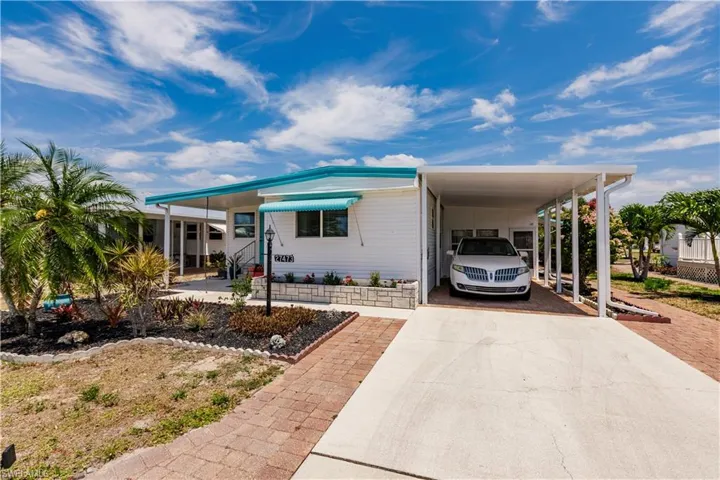 Manufactured / mobile home featuring a carport and concrete driveway