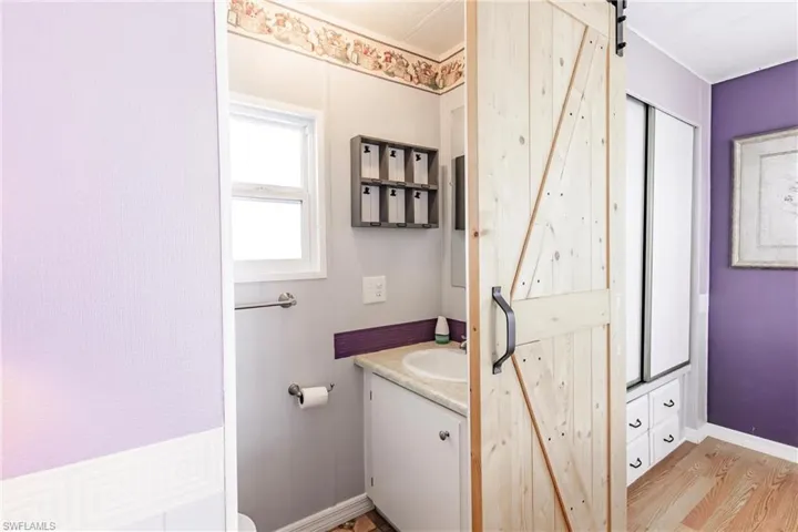 Bathroom with baseboards, vanity, and wood finished floors