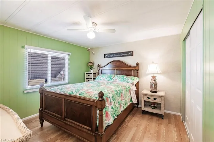 Bedroom with baseboards, wood finished floors, a closet, and ceiling fan