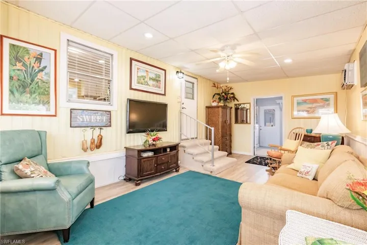 Sitting Room with a drop ceiling, recessed lighting, a ceiling fan, wood finished floors, and stairway
