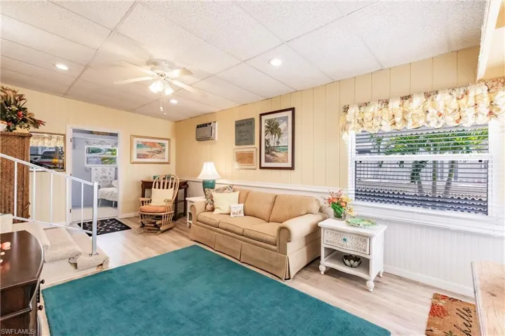 Sitting room with recessed lighting, a ceiling fan, wood finished floors, and a wall unit AC