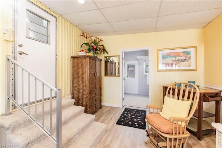 Sitting room featuring baseboards, wood finished floors, and stairway