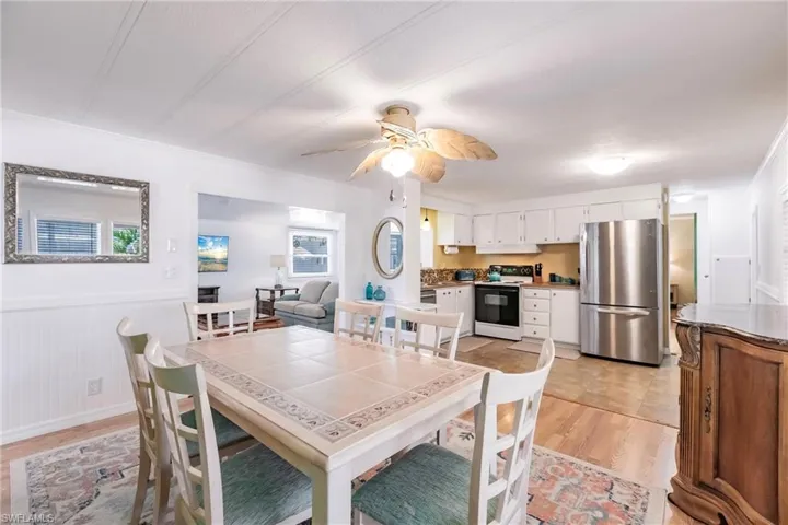 Dining area featuring wainscoting, a ceiling fan, and light wood-type flooring