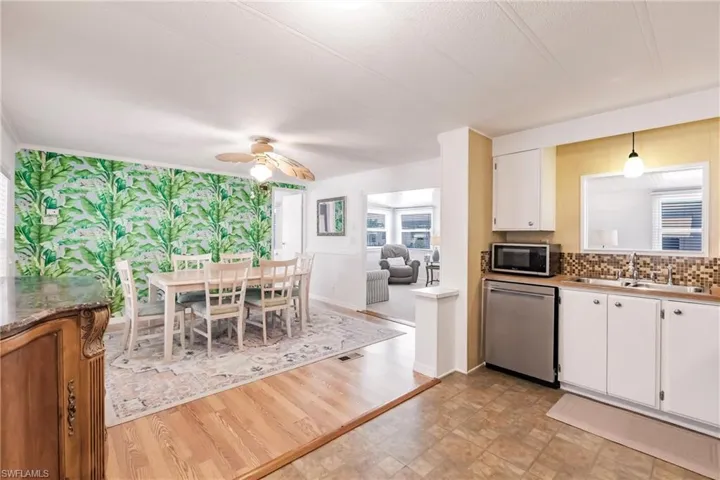 Kitchen featuring a sink, ceiling fan, white cabinets, appliances with stainless steel finishes, and visible vents