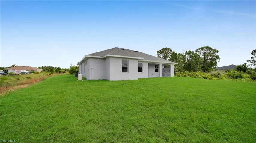 Back of property featuring stucco siding and a yard