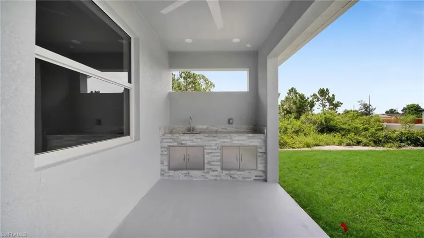 View of patio with an outdoor kitchen and a sink