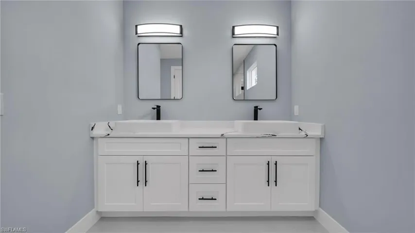 Bathroom with baseboards and double vanity