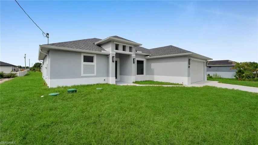 Prairie-style home with a garage, stucco siding, roof with shingles, and a front yard