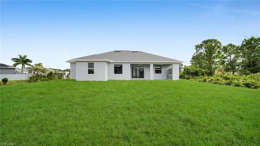 Rear view of house with a yard and stucco siding