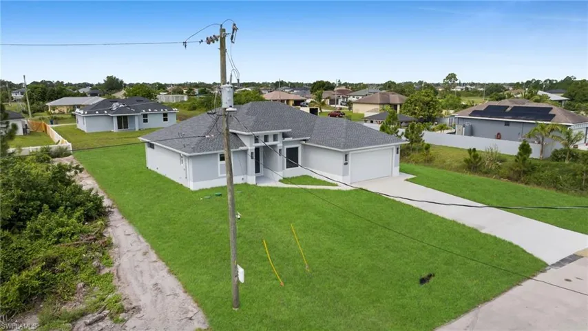 Ranch-style house featuring a residential view, driveway, a shingled roof, and an attached garage