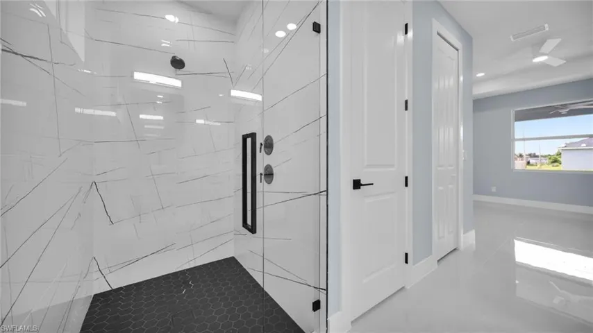 Full bath with a marble finish shower