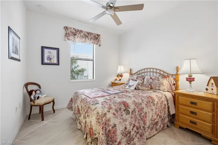 Bedroom with ceiling fan and light tile patterned floors