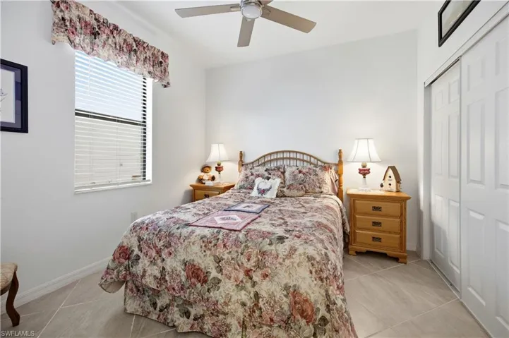 Bedroom with a closet, ceiling fan, and light tile patterned flooring