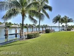 View of dock with a yard and a water view