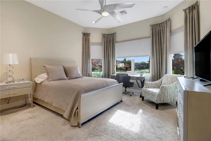 Carpeted bedroom featuring ceiling fan