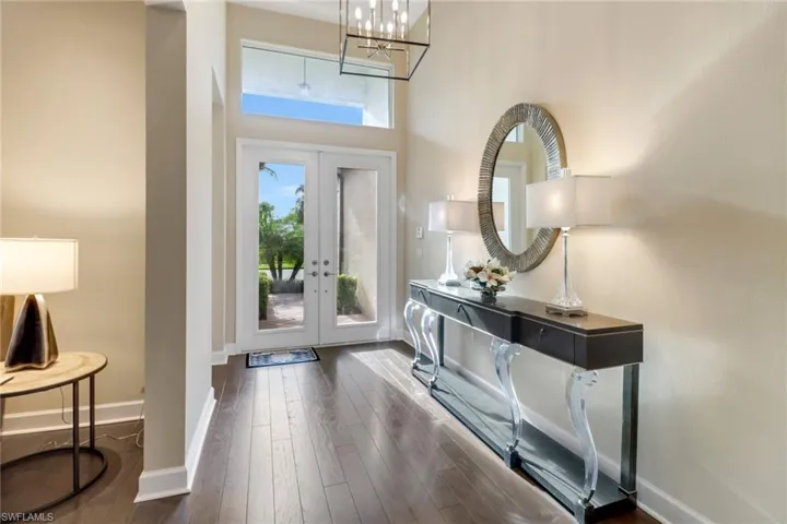 Entryway featuring plenty of natural light, dark hardwood floors, french doors, and a towering ceiling