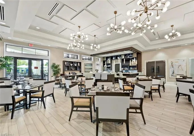 Dining room with a notable chandelier and a raised ceiling