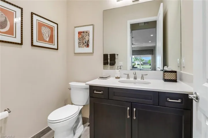 Bathroom featuring vanity, toilet, and hardwood flooring