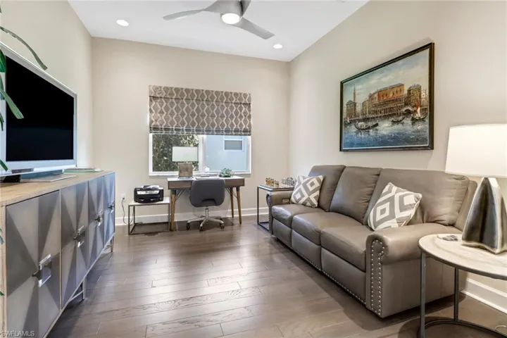 Living room featuring dark hardwood floors and ceiling fan