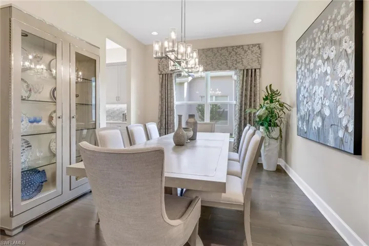 Dining area featuring dark hardwood floors and a notable chandelier
