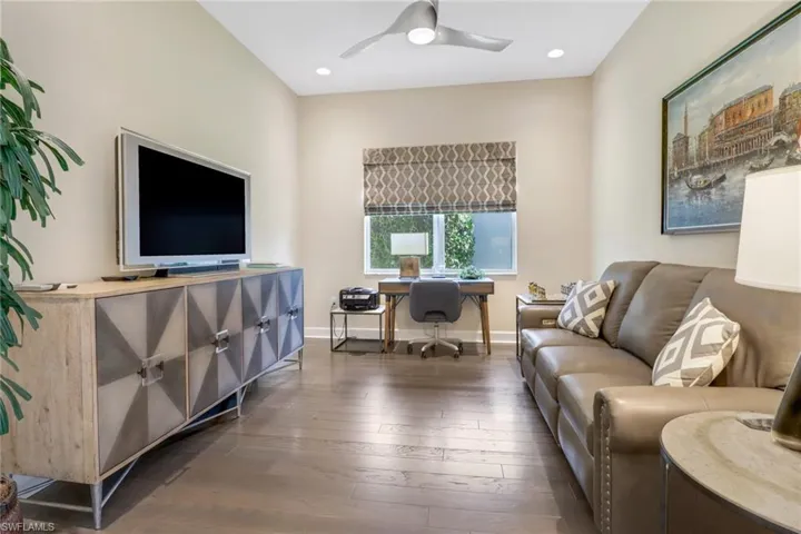 Living room featuring dark hardwood floors and ceiling fan