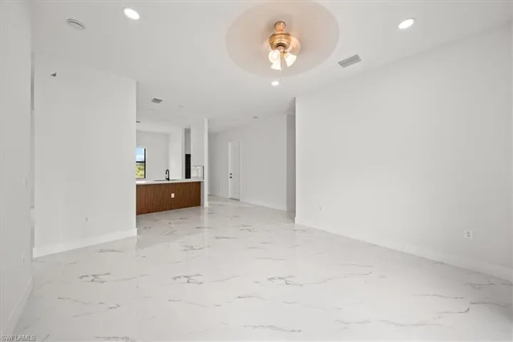 Unfurnished room featuring a ceiling fan, recessed lighting, and light marble finish floors