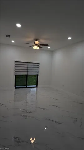 Empty room featuring marble tiled flooring, recessed lighting, and a ceiling fan