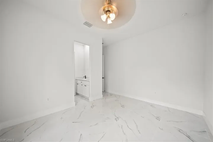 Spare room featuring ceiling fan and light marble finish floors