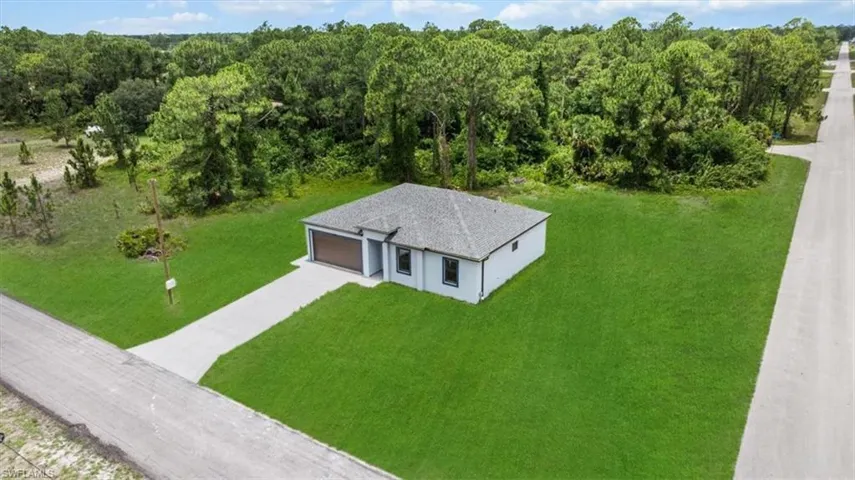 Aerial view of property and surrounding area featuring a heavily wooded area